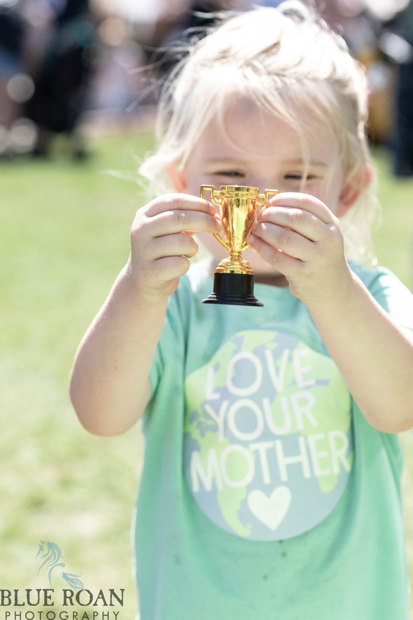 Child holding a small gold trophy at Family Fun Fest